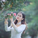 woman holding pink petaled flower