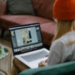 woman sitting on a sofa and editing pictures on a laptop