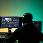 a man sitting on front of the computer while editing video