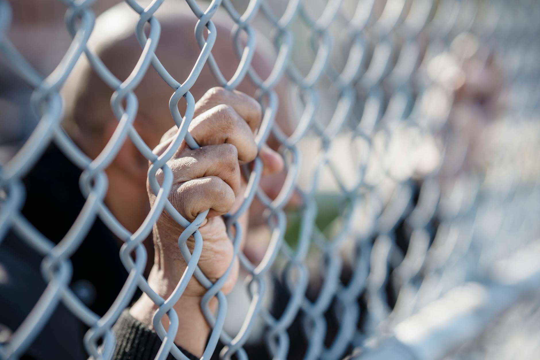 person holding a wire fence